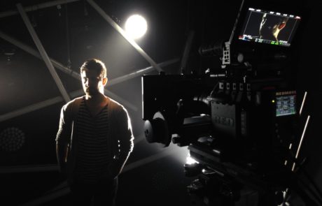 Man standing under lights in a video production studio